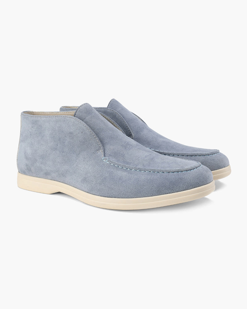 Pair of light blue suede shoes on a white background