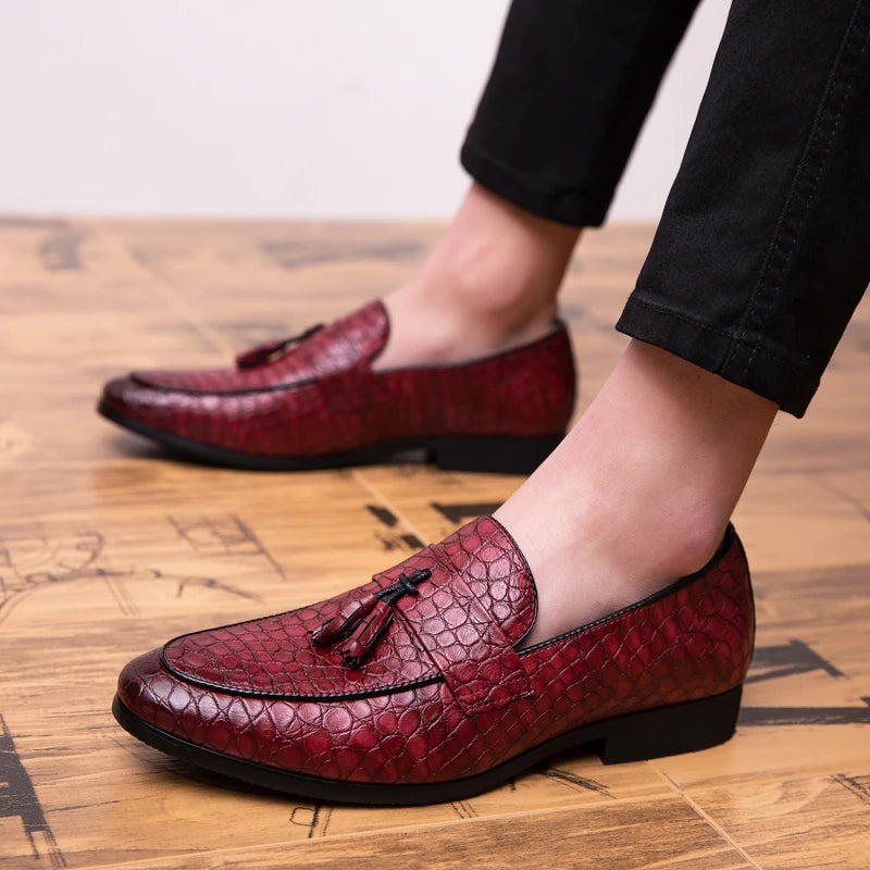 Red leather loafers worn on a wooden floor