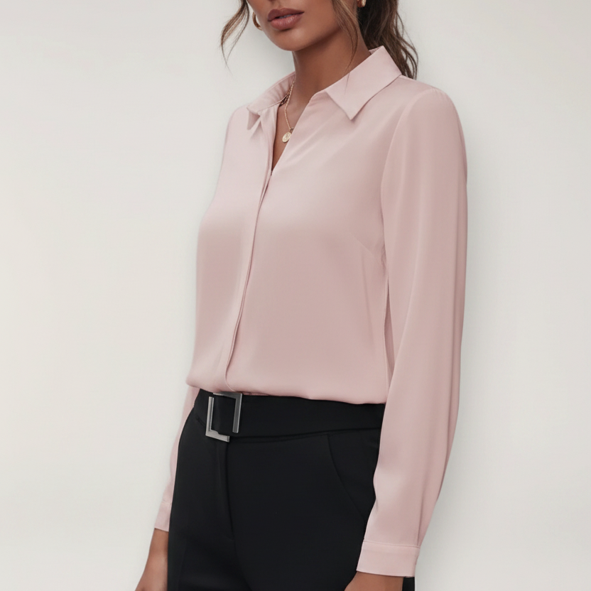 Person wearing a light pink blouse and black pants against a white background