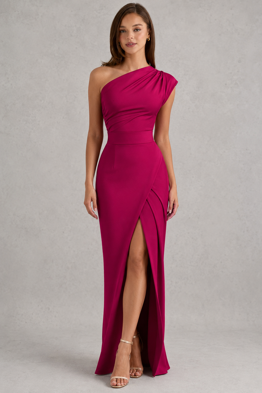 Woman wearing a magenta one-shoulder dress with a slit on a gray background