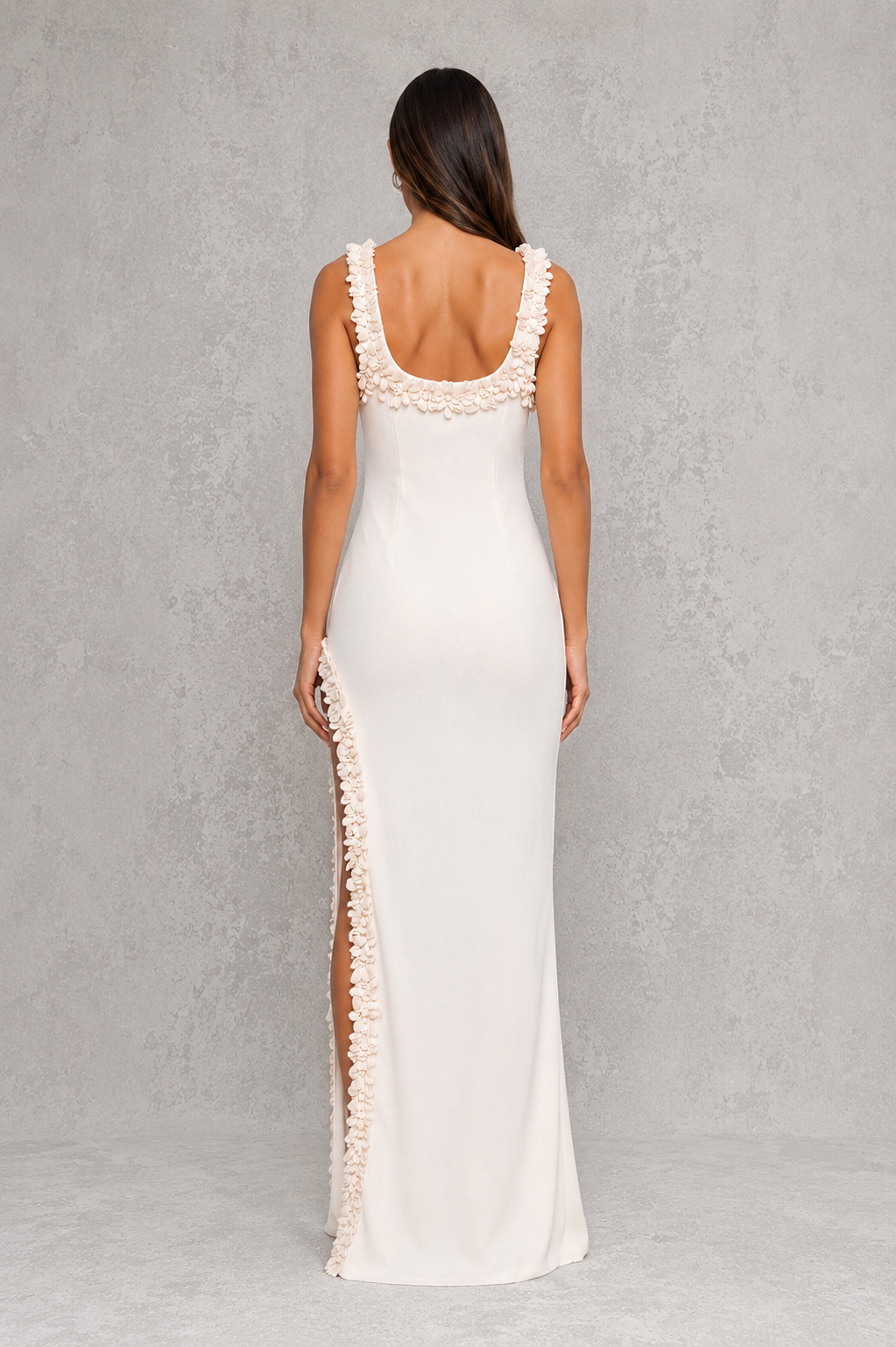 Woman wearing a white dress with lace details on a gray background