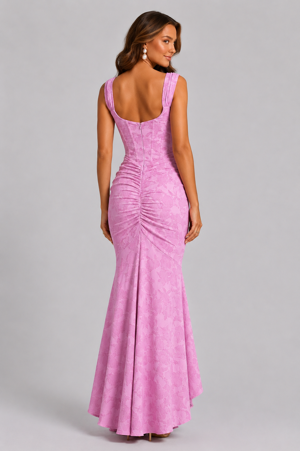 Woman wearing a pink evening gown against a gray background