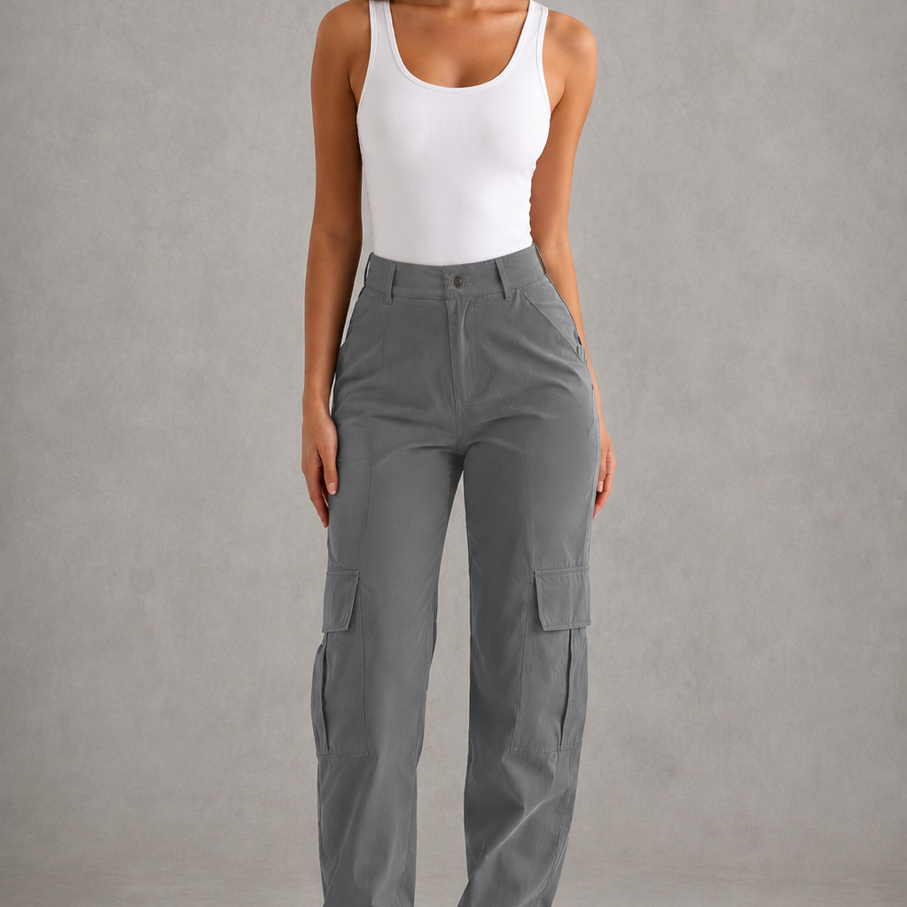 Woman wearing gray cargo pants and a white tank top against a gray background