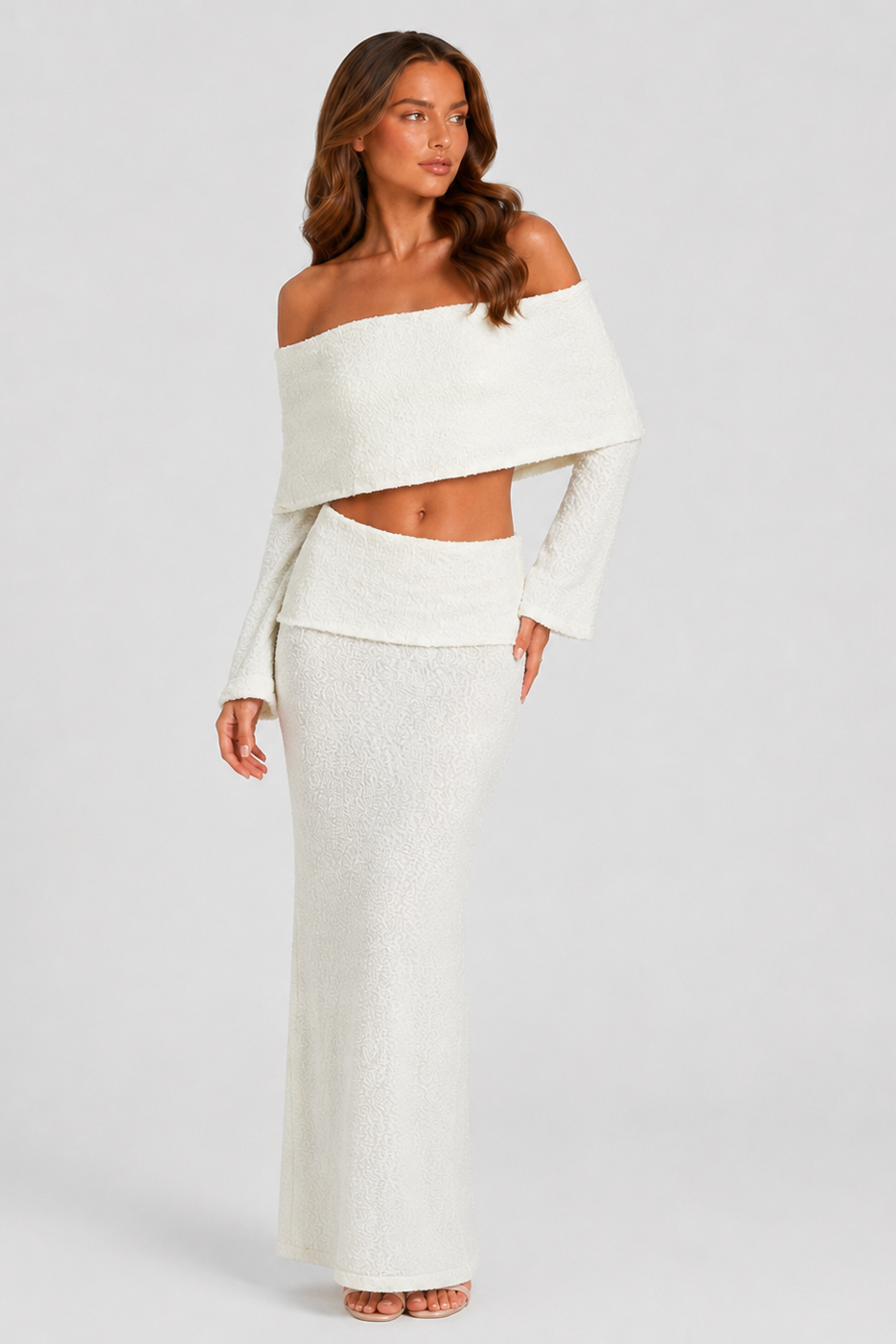 Woman wearing a white off-shoulder top and skirt set against a plain background