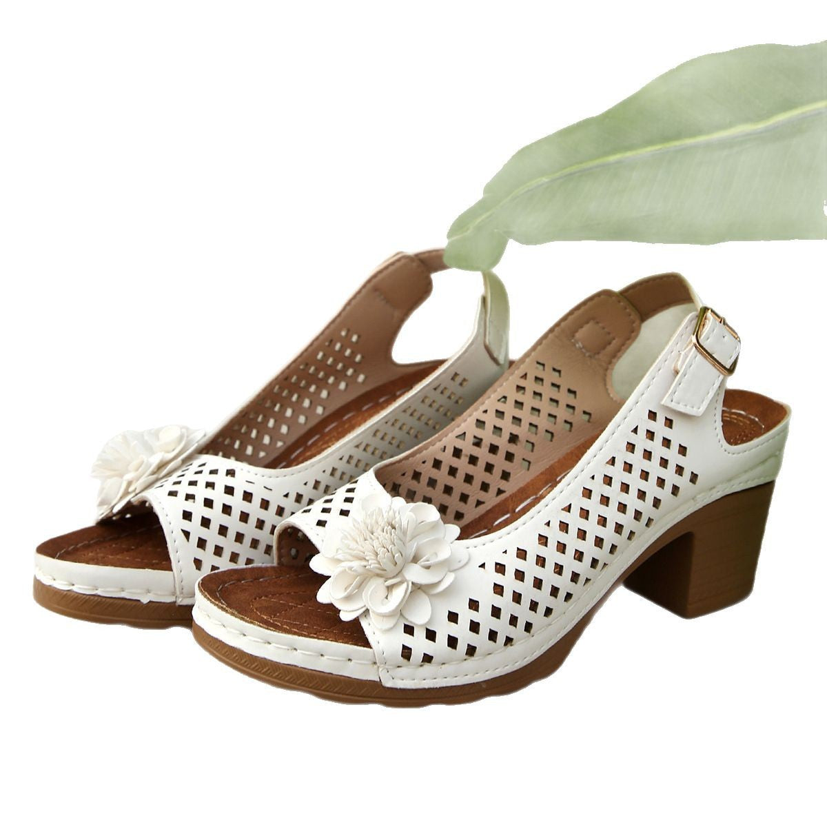 Pair of white open-toe shoes with brown soles and flowers on a white background