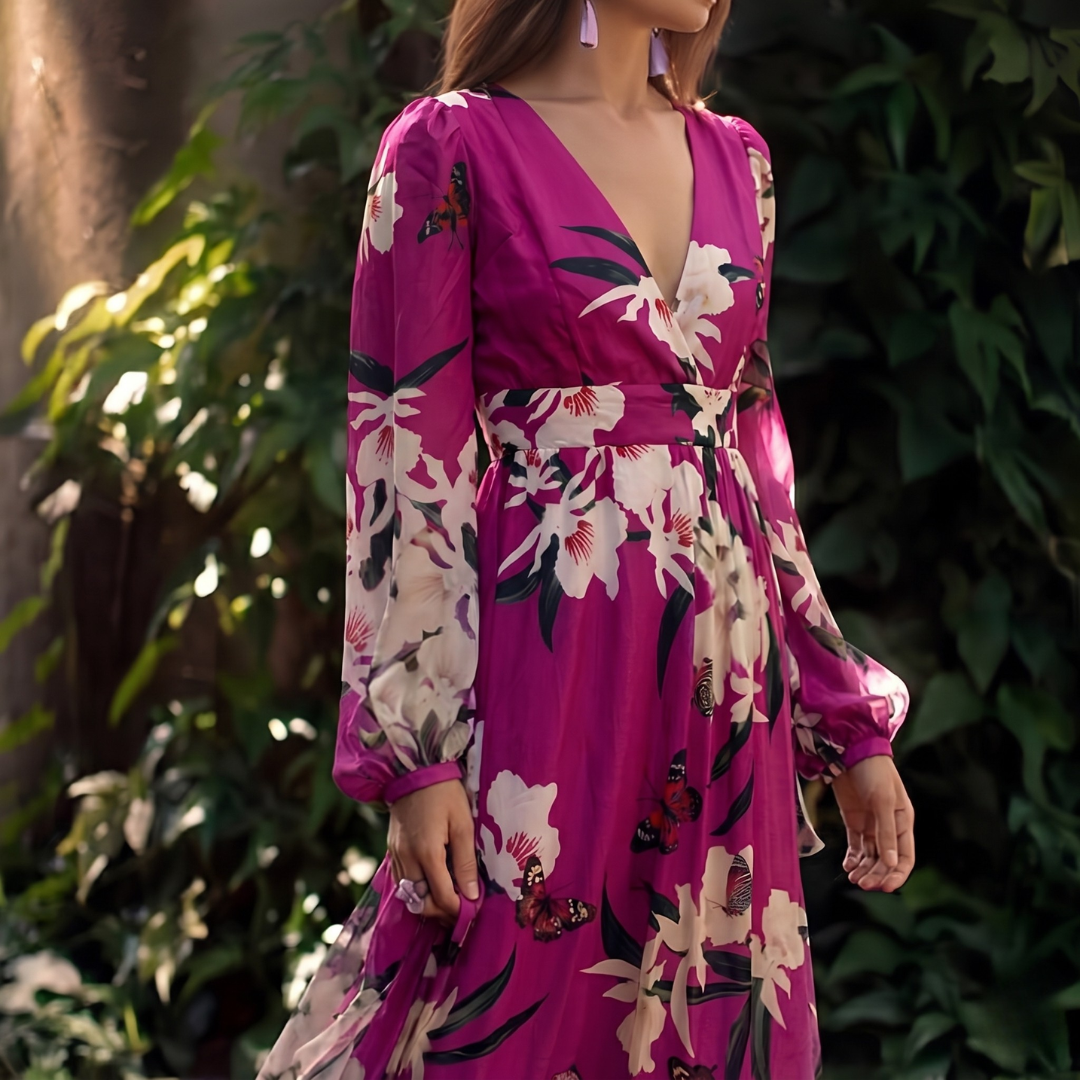 Woman wearing a pink floral dress with greenery in the background