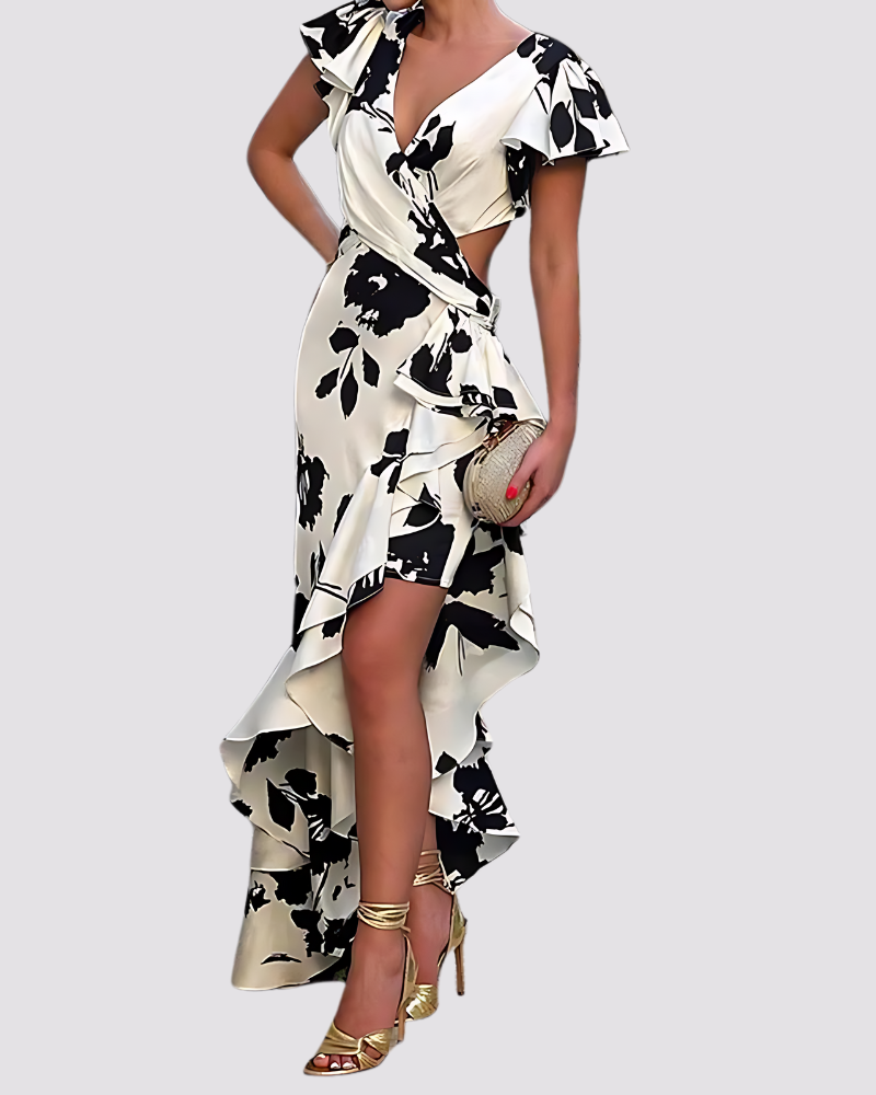 Woman wearing a black and white floral dress with gold shoes on a light gray background