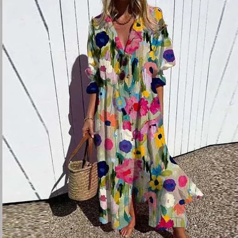 Woman wearing a colorful floral dress holding a straw bag against a white wall.