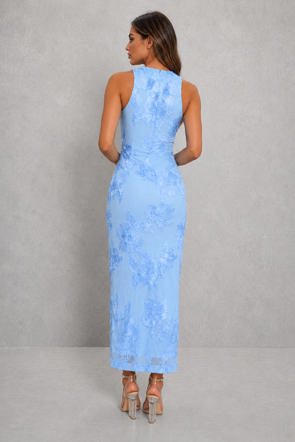 Woman wearing a light blue lace dress against a gray background
