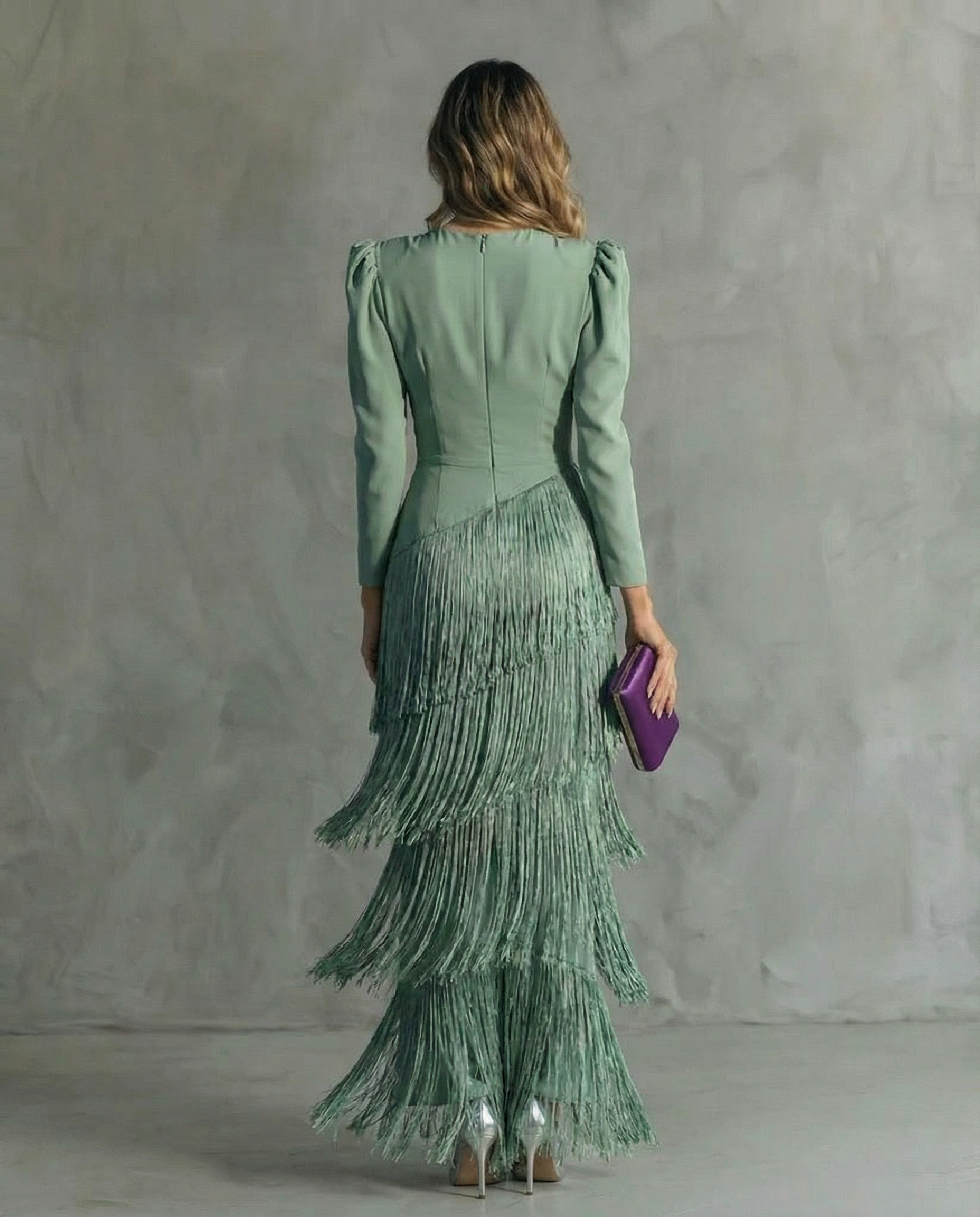Woman wearing a green dress with a textured pattern against a gray background