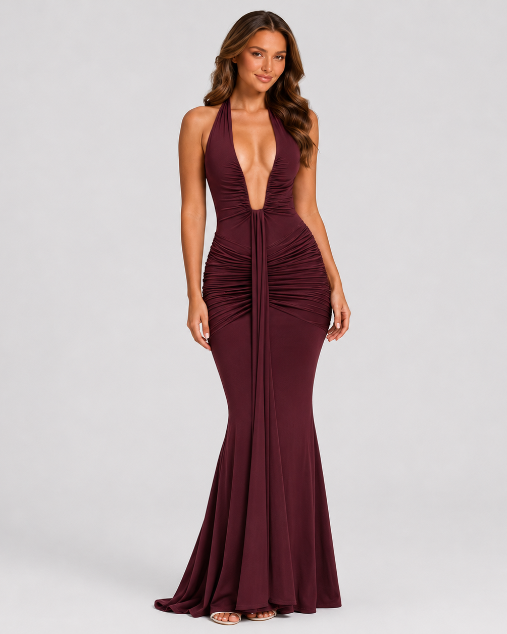 Woman wearing a burgundy evening gown on a gray background