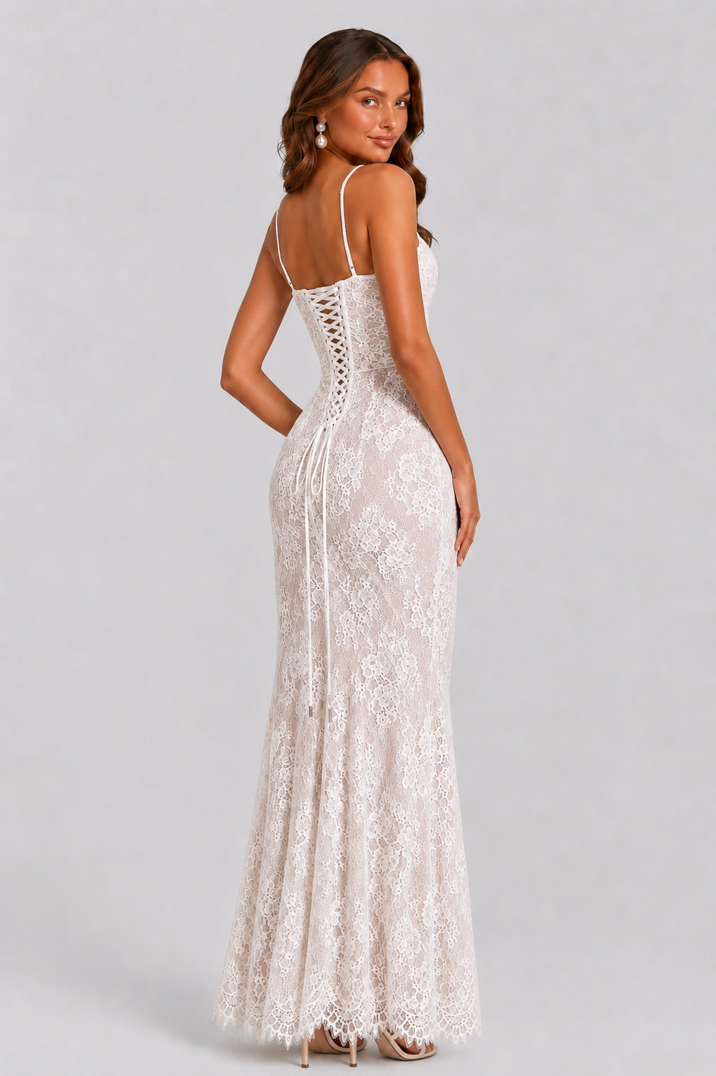 Woman wearing a white lace dress on a gray background