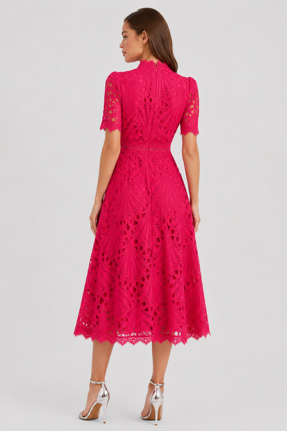 Woman wearing a pink lace dress on a white background