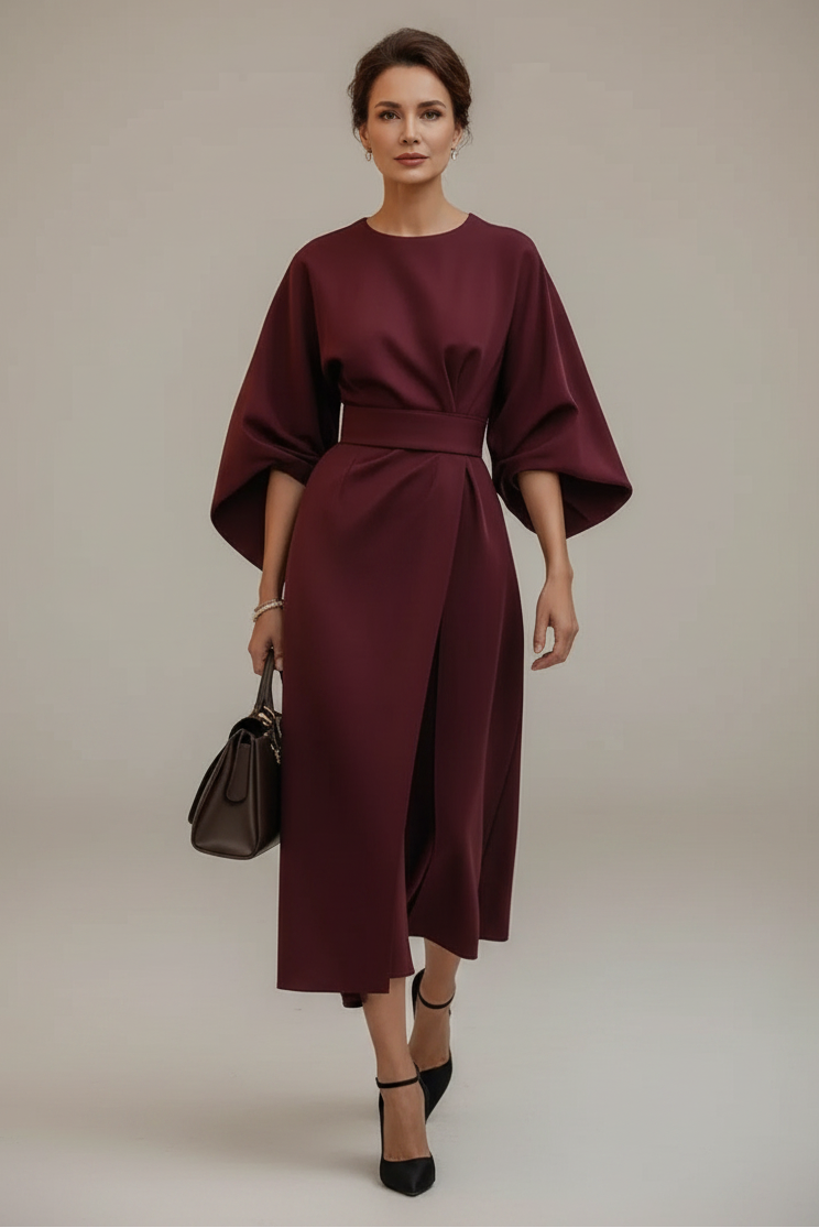 Woman in a burgundy dress walking on a city street.