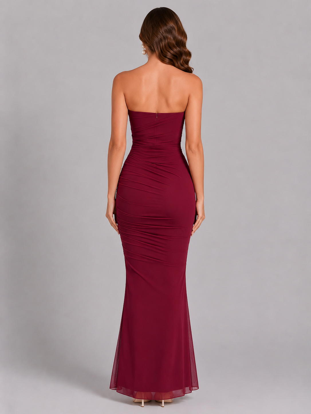 Burgundy strapless gown on a gray background