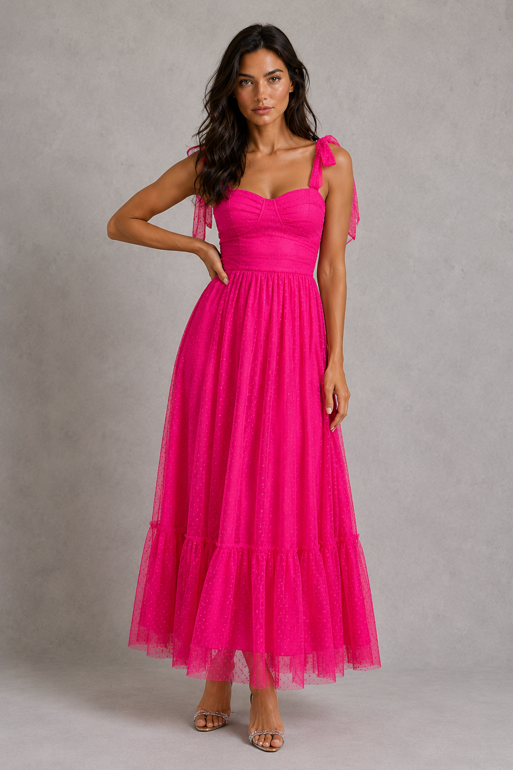Woman wearing a bright pink dress against a gray background