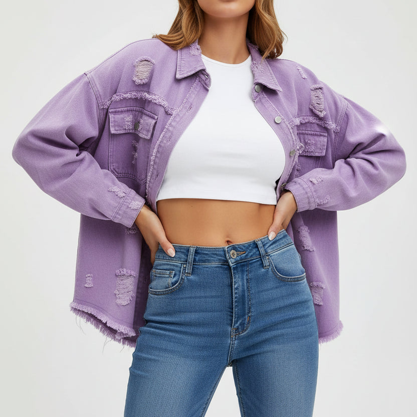 Woman wearing a light purple denim jacket, white top, and blue jeans against a gray background