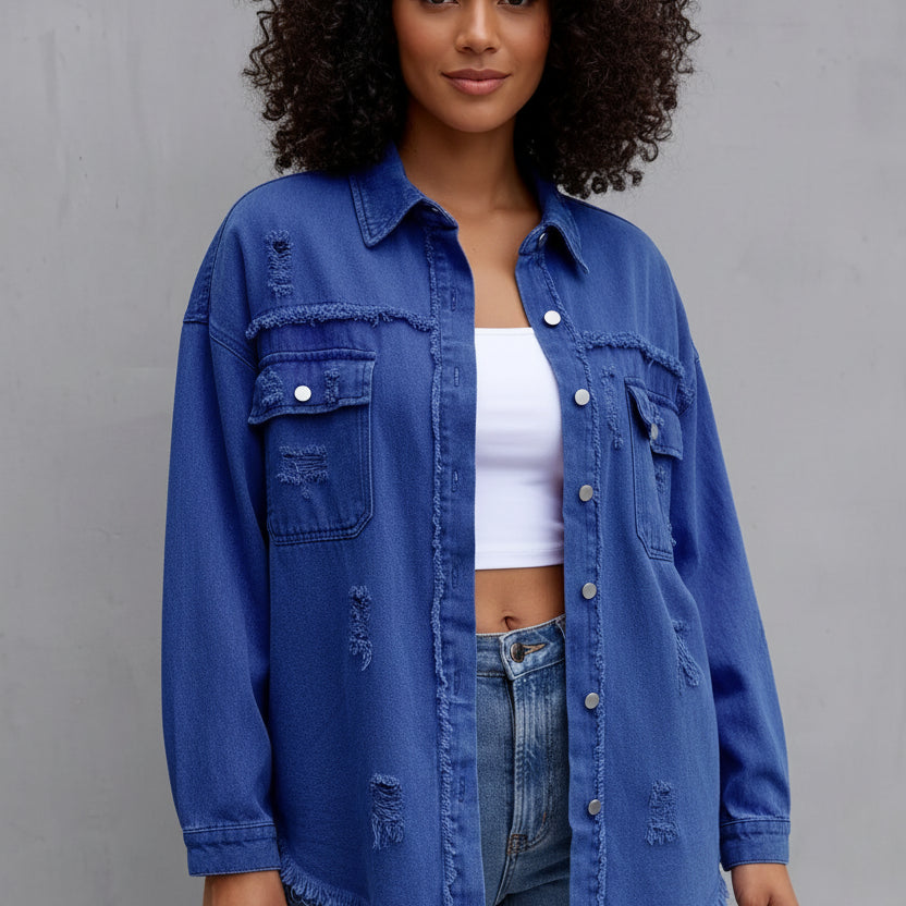 Woman wearing a blue denim jacket and jeans against a gray background
