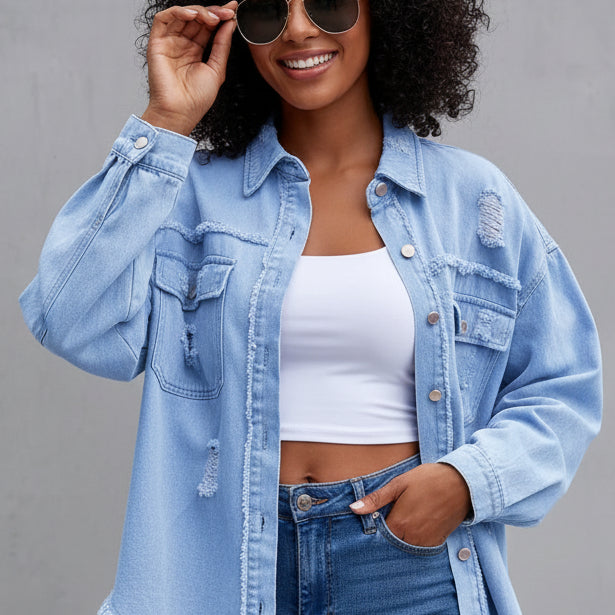 Woman wearing a light blue denim jacket and jeans against a gray background