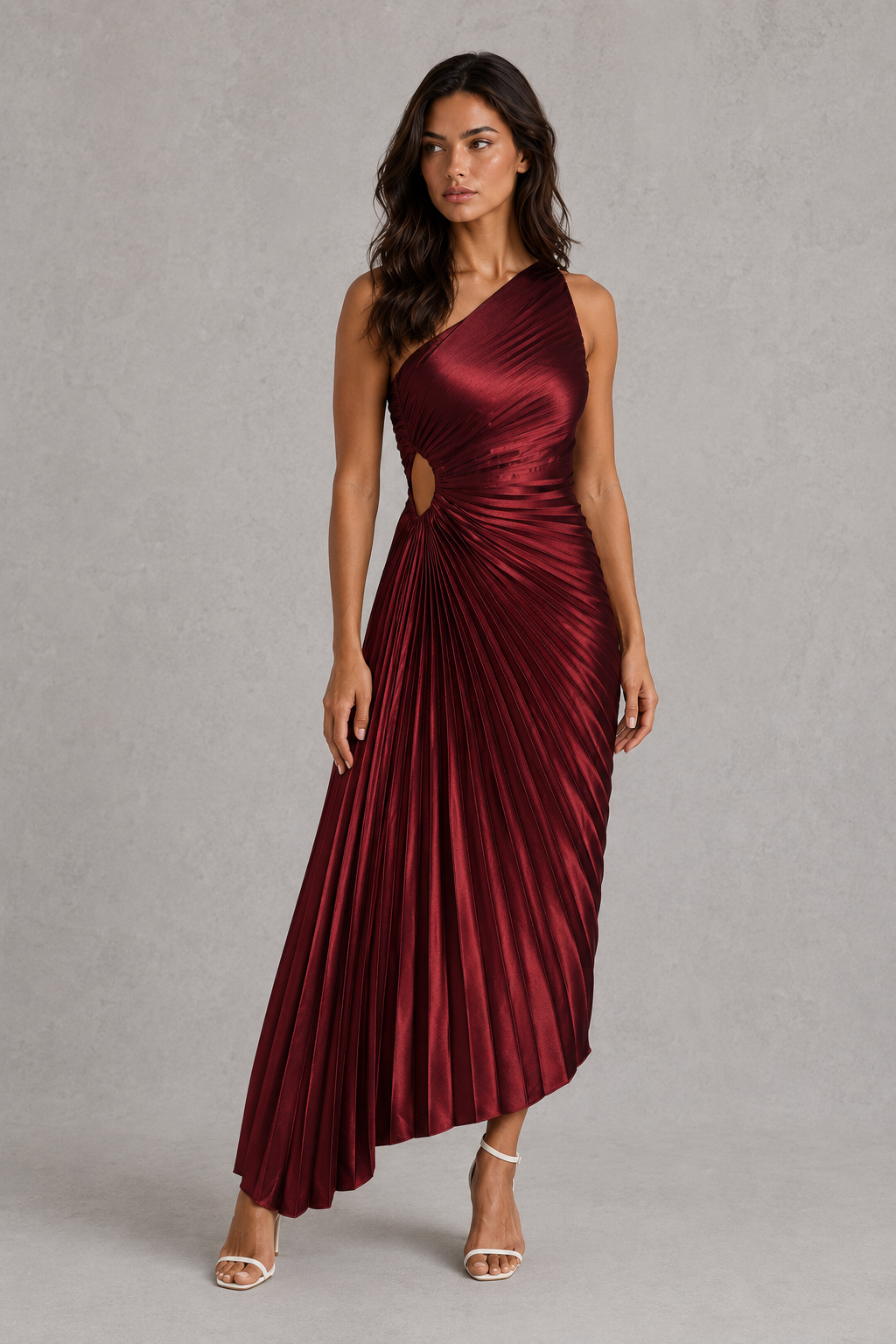 Woman wearing a burgundy one-shoulder dress with a cutout detail on a gray background