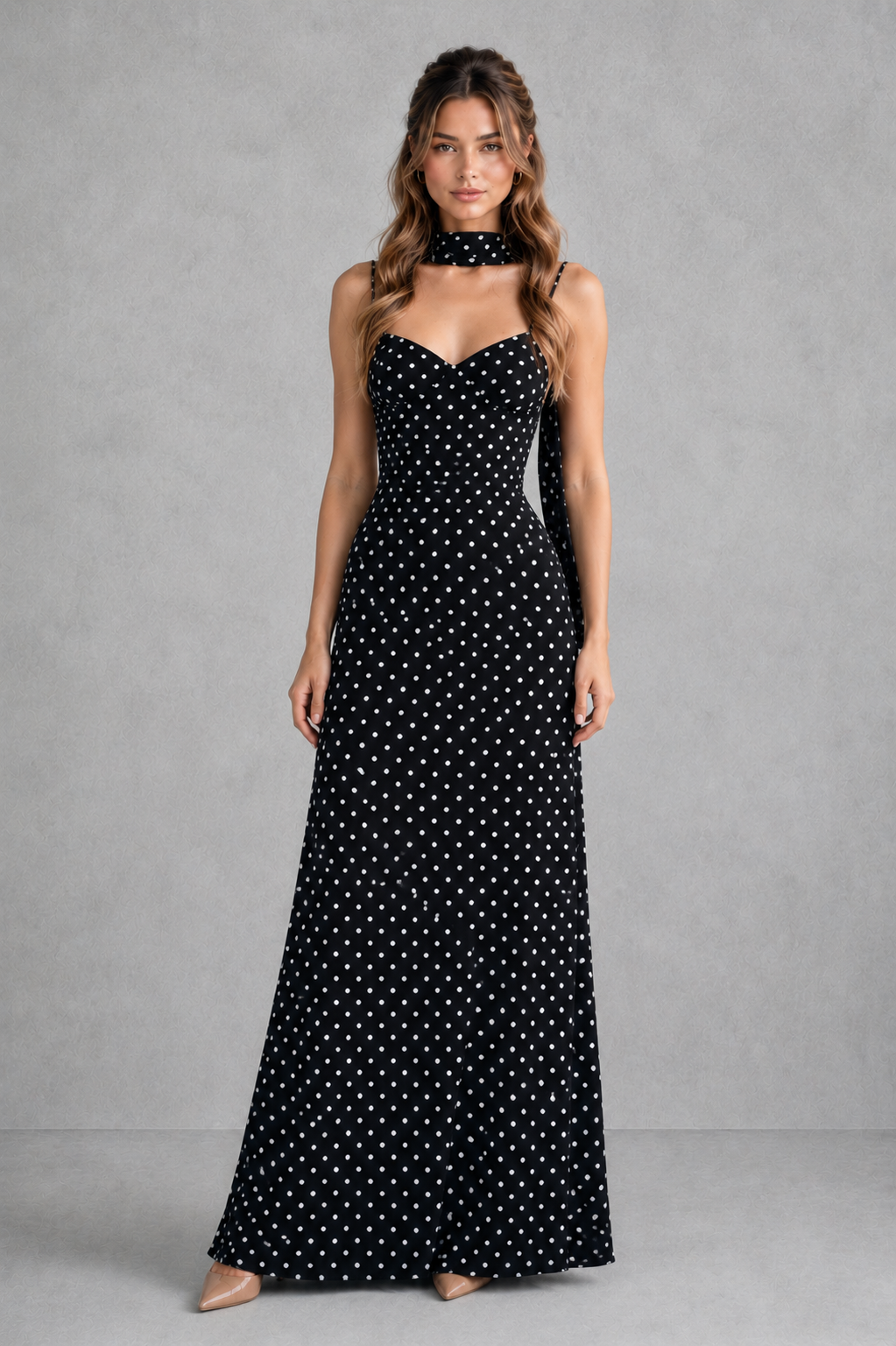 Woman wearing a black strapless dress with white polka dots against a gray background