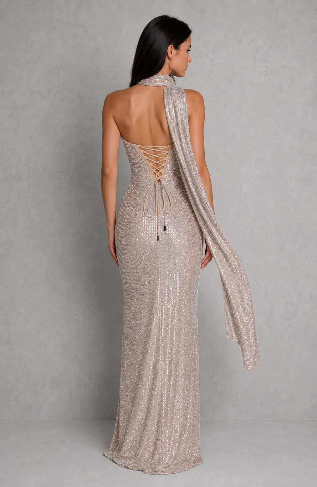 Woman wearing a sparkly evening gown with a plain background
