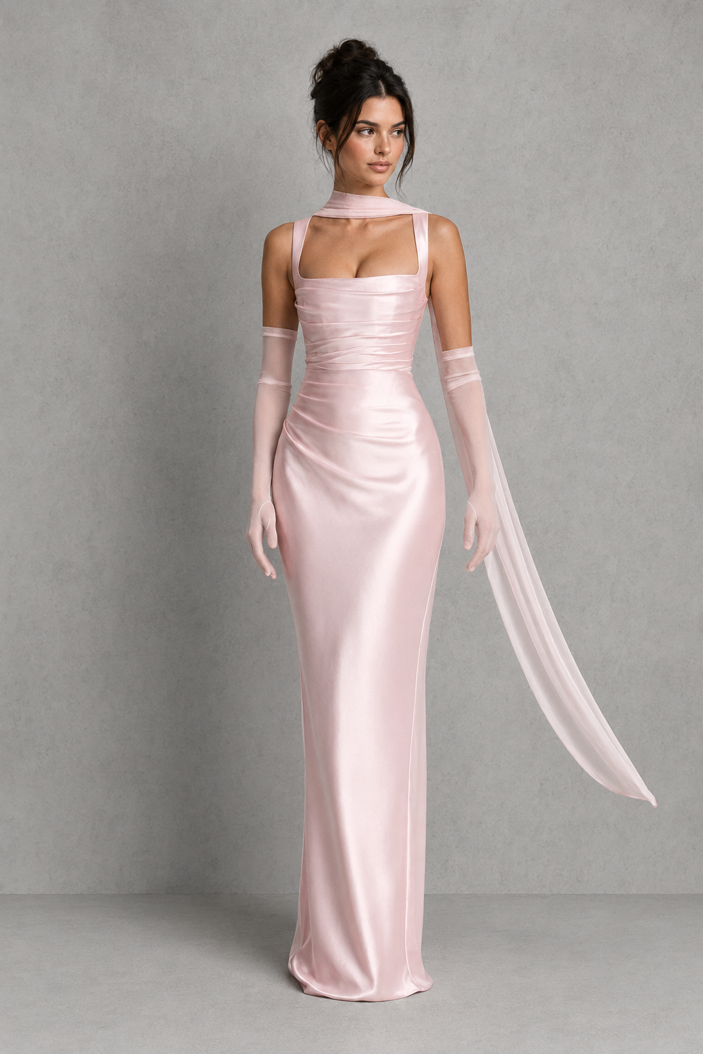 Woman wearing a pink satin evening gown with gloves against a gray background