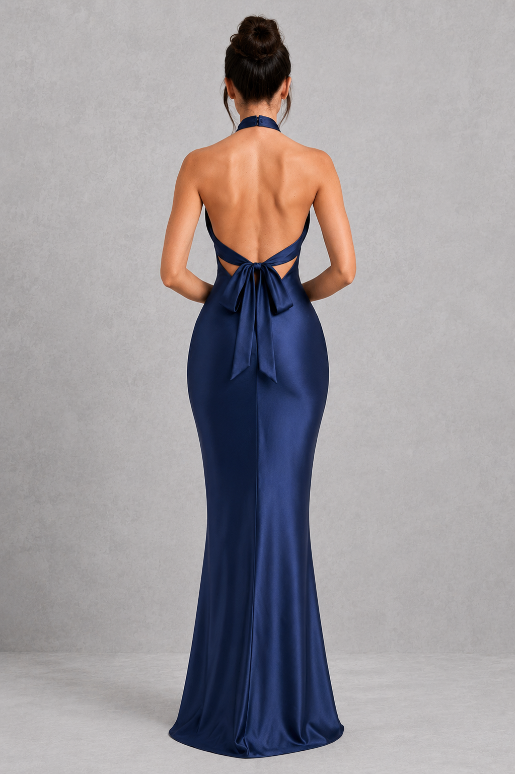 Navy blue evening gown with open back on a gray background