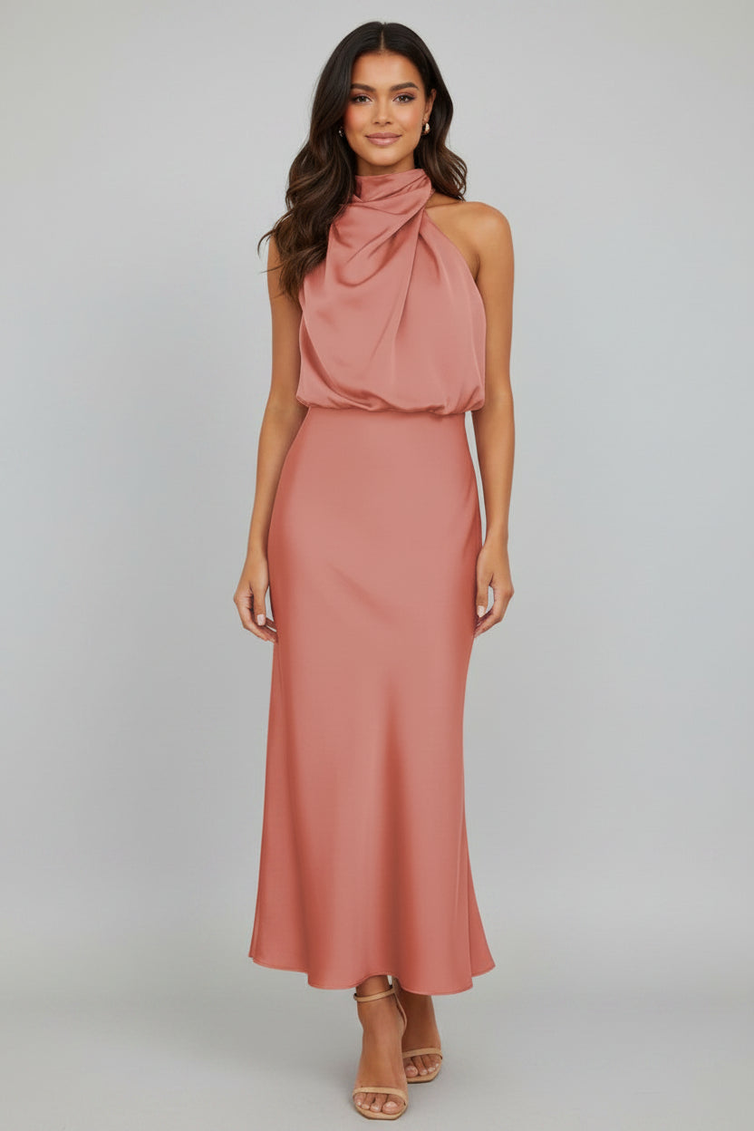 Woman wearing a pink halter neck dress on a white background