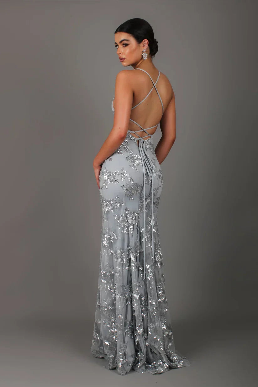 Woman wearing a silver sequin gown against a gray background