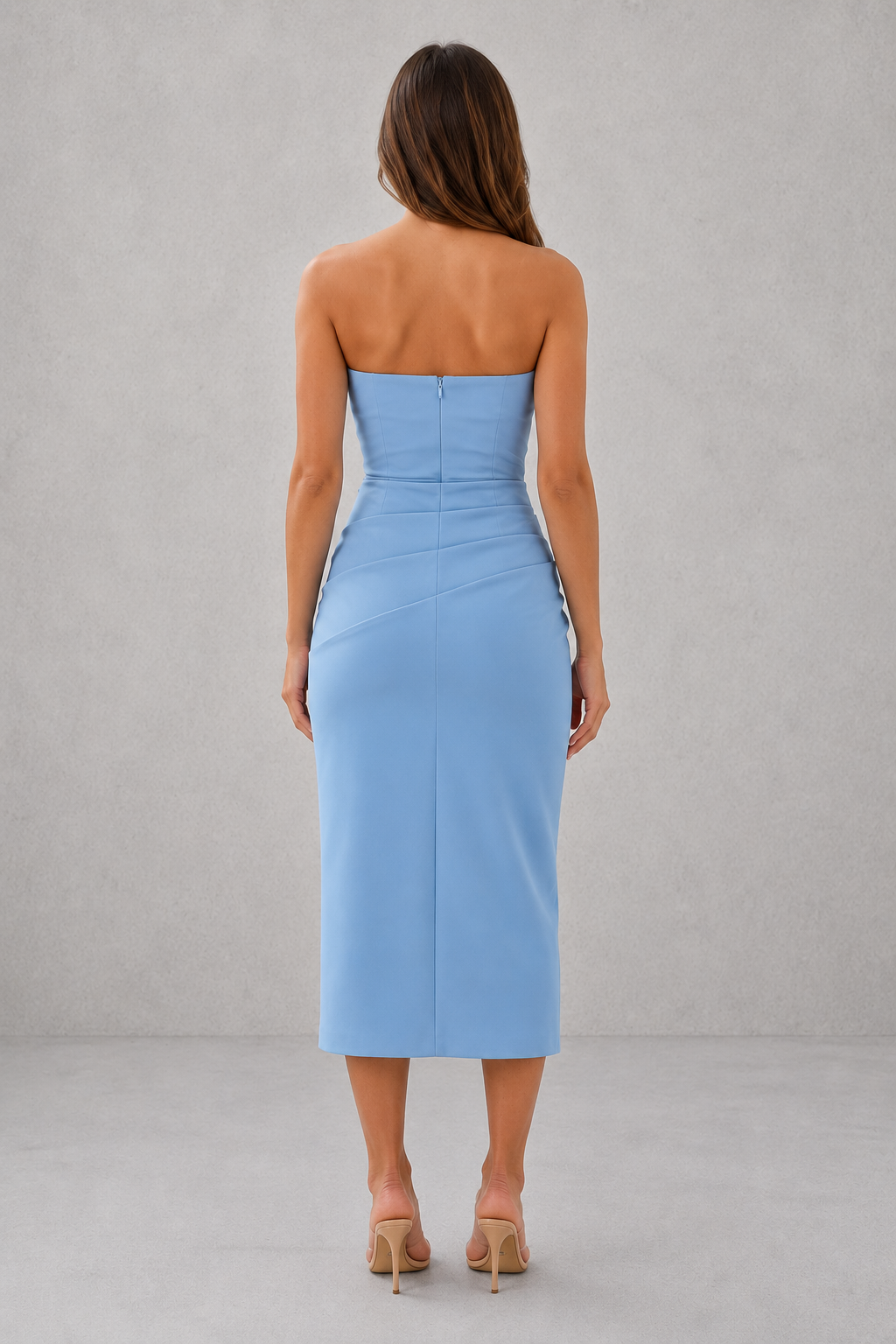 Woman wearing a light blue strapless dress against a gray background