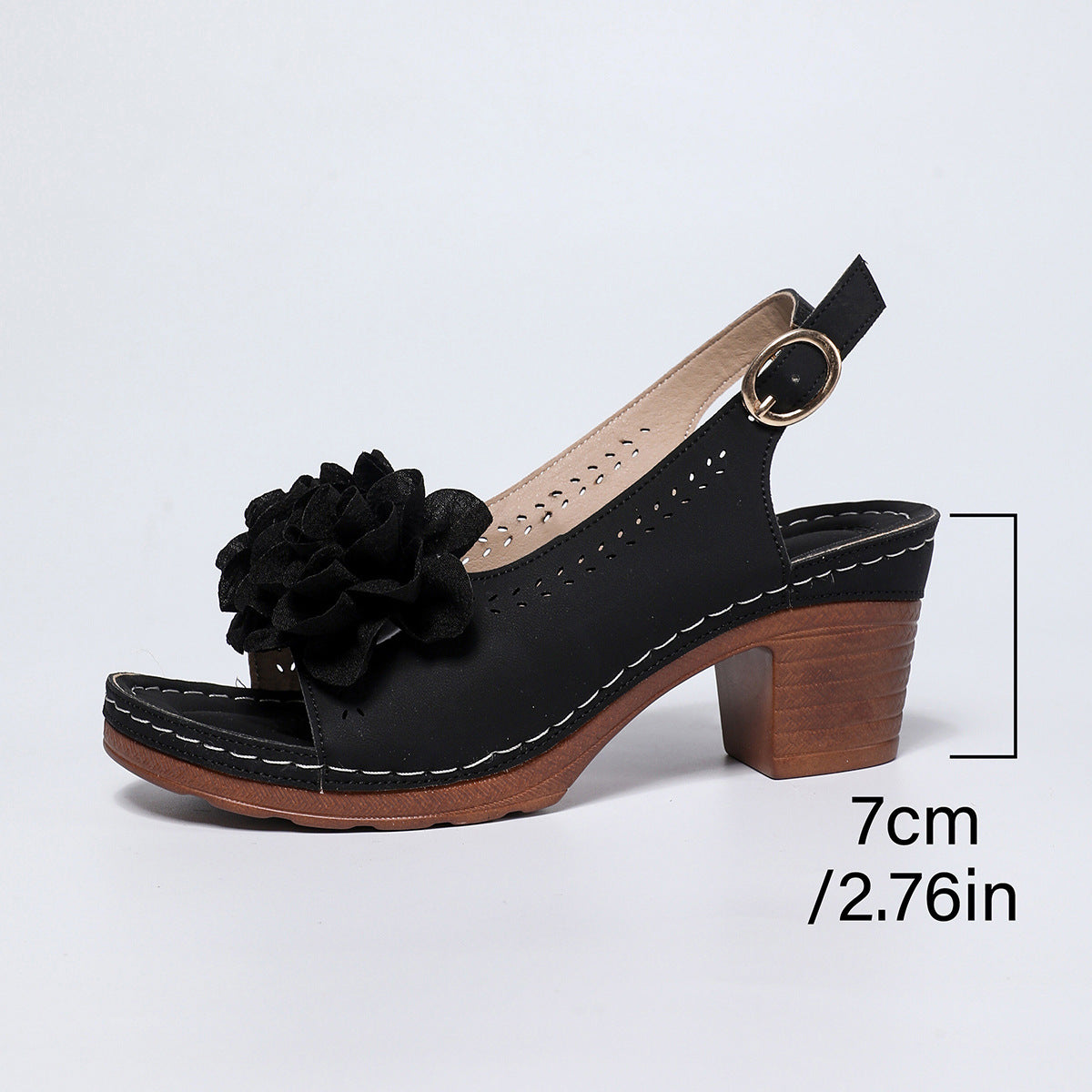 Black sandal with a wooden heel and floral detail on a light gray background