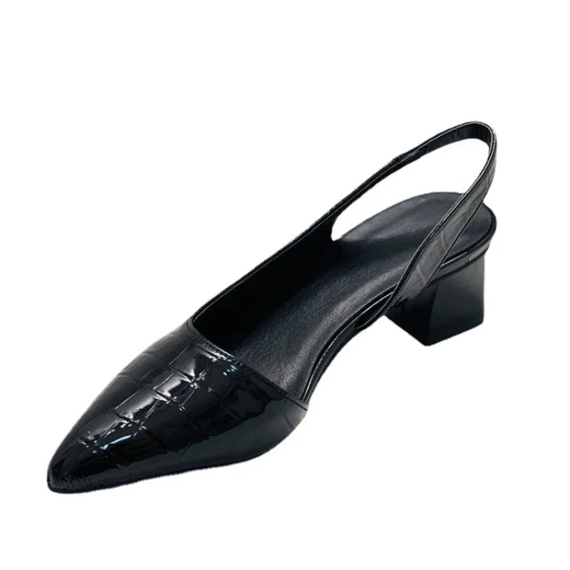 Black patent leather slingback shoe on a white background