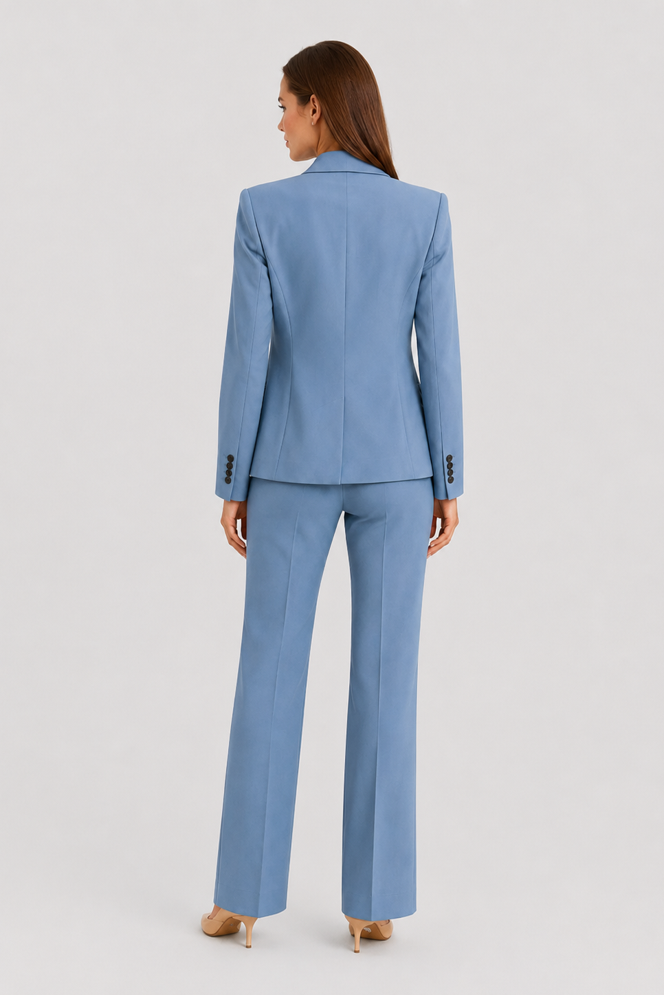 Woman wearing a light blue suit on a plain background