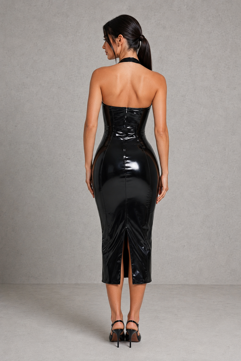 Woman wearing a black patent leather dress against a gray background