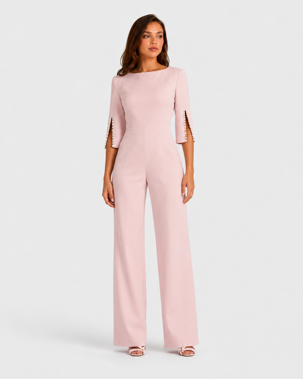 Woman wearing a light pink jumpsuit on a white background