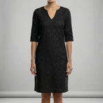 Black lace dress worn by a person on a gray background