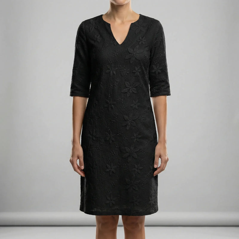 Black lace dress worn by a person on a gray background