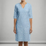 Light blue dress with floral patterns on a gray background