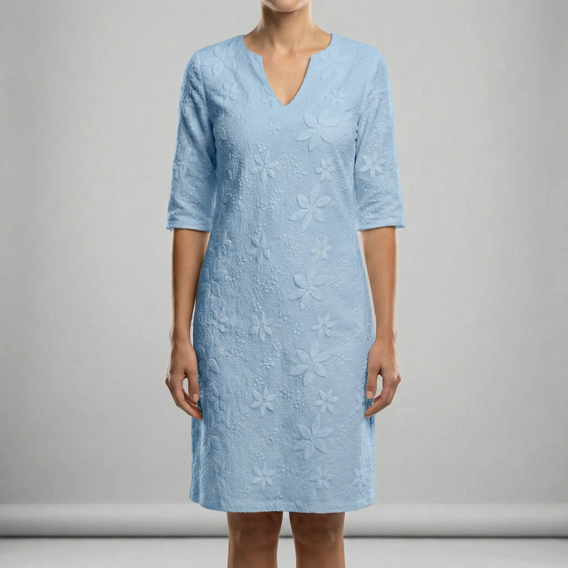 Light blue dress with floral patterns on a gray background