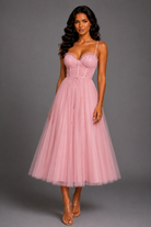 Woman wearing a pink dress against a gray background