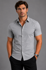 Man wearing a gray short-sleeve shirt against a gray background