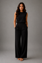 Woman wearing a black outfit against a gray background