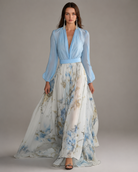 Woman wearing a light blue blouse and floral skirt on a gray background