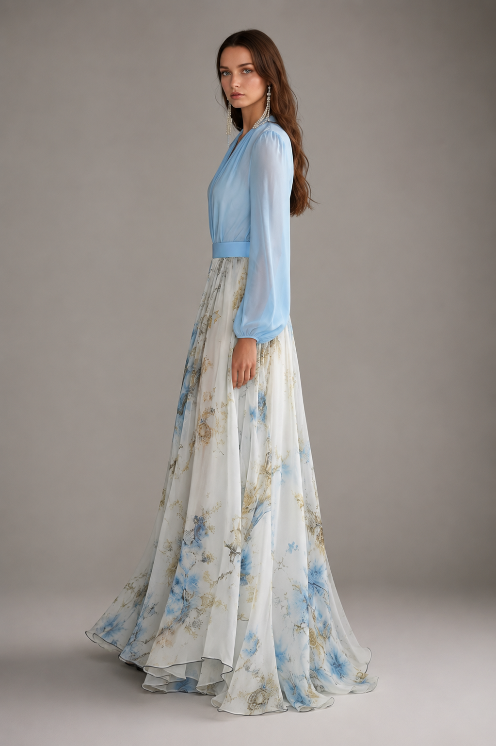Woman wearing a light blue top and floral skirt against a neutral background