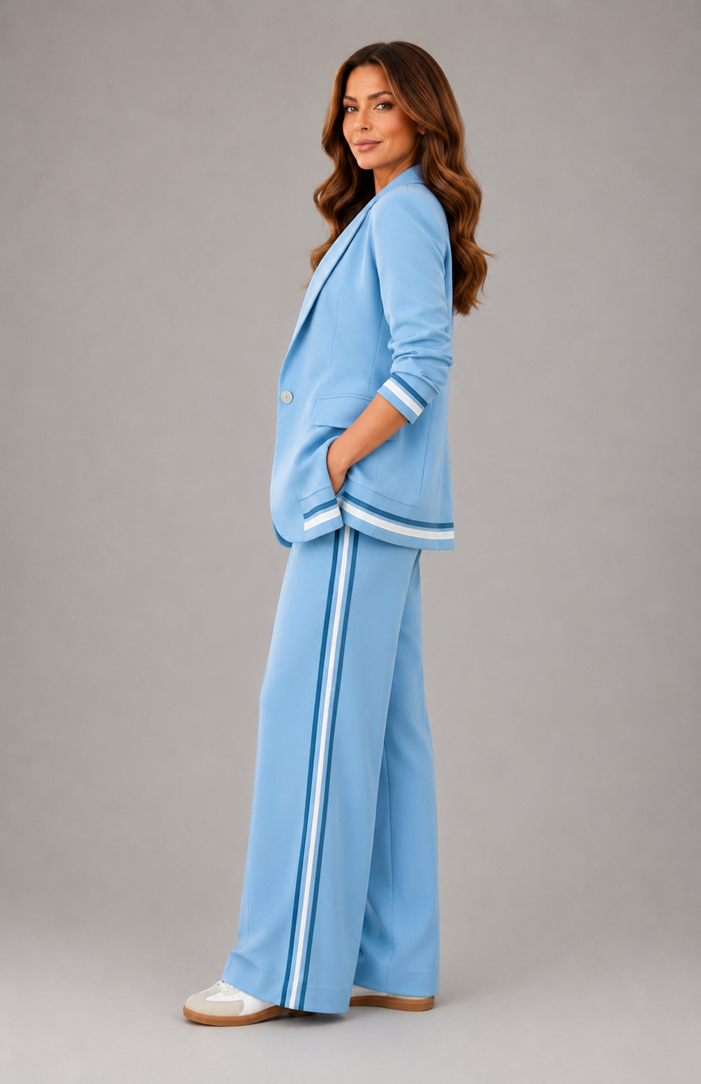 Woman wearing a light blue suit with white stripes on a gray background