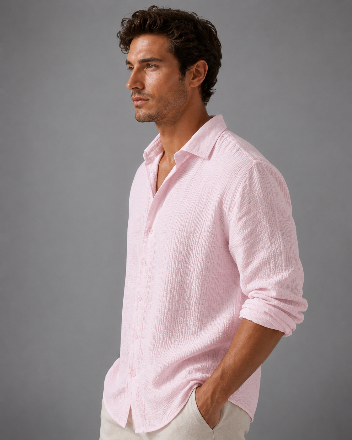 Man wearing a light pink shirt against a gray background