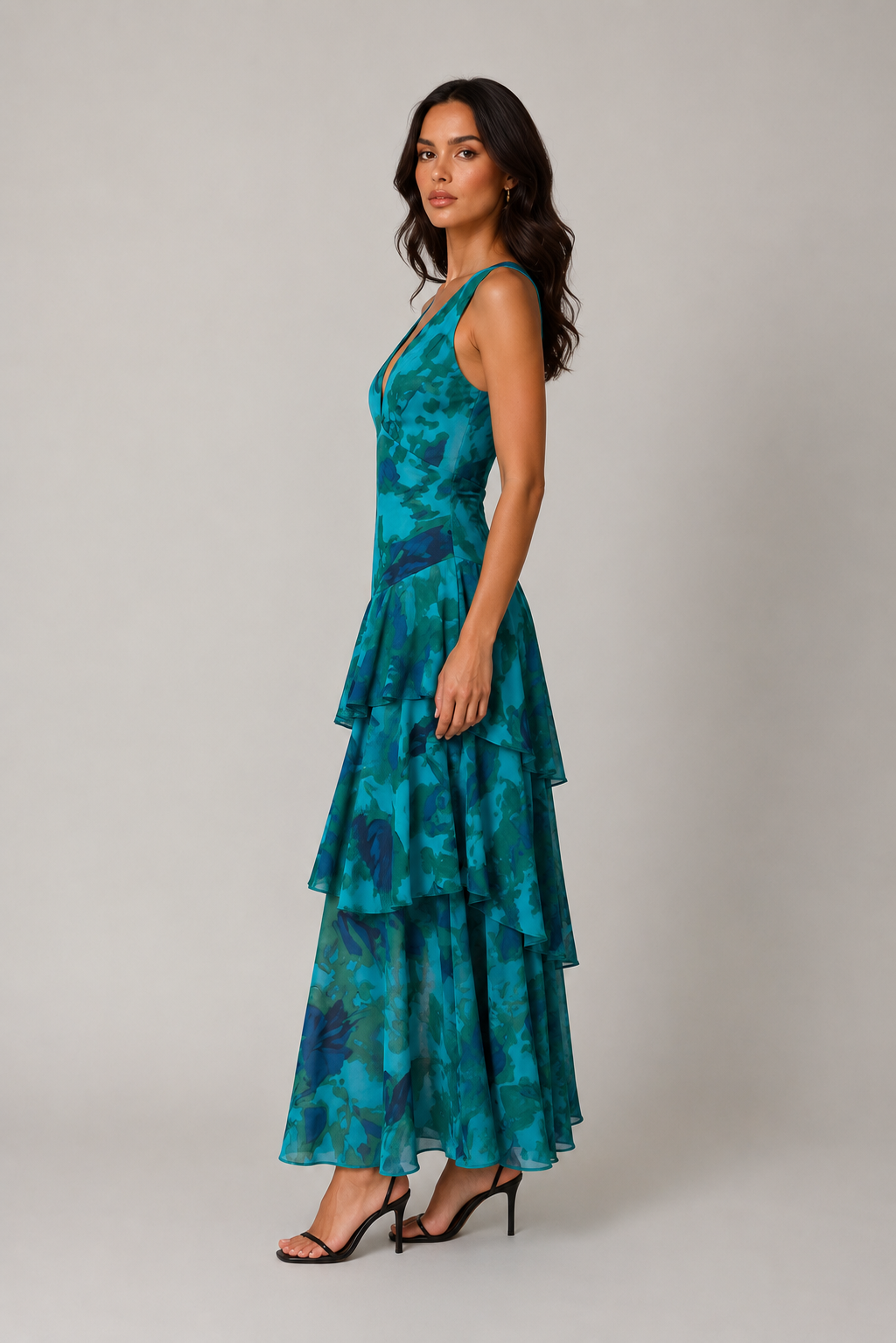 Woman wearing a teal and blue patterned dress on a plain background