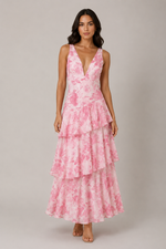 Woman wearing a pink floral dress against a plain background