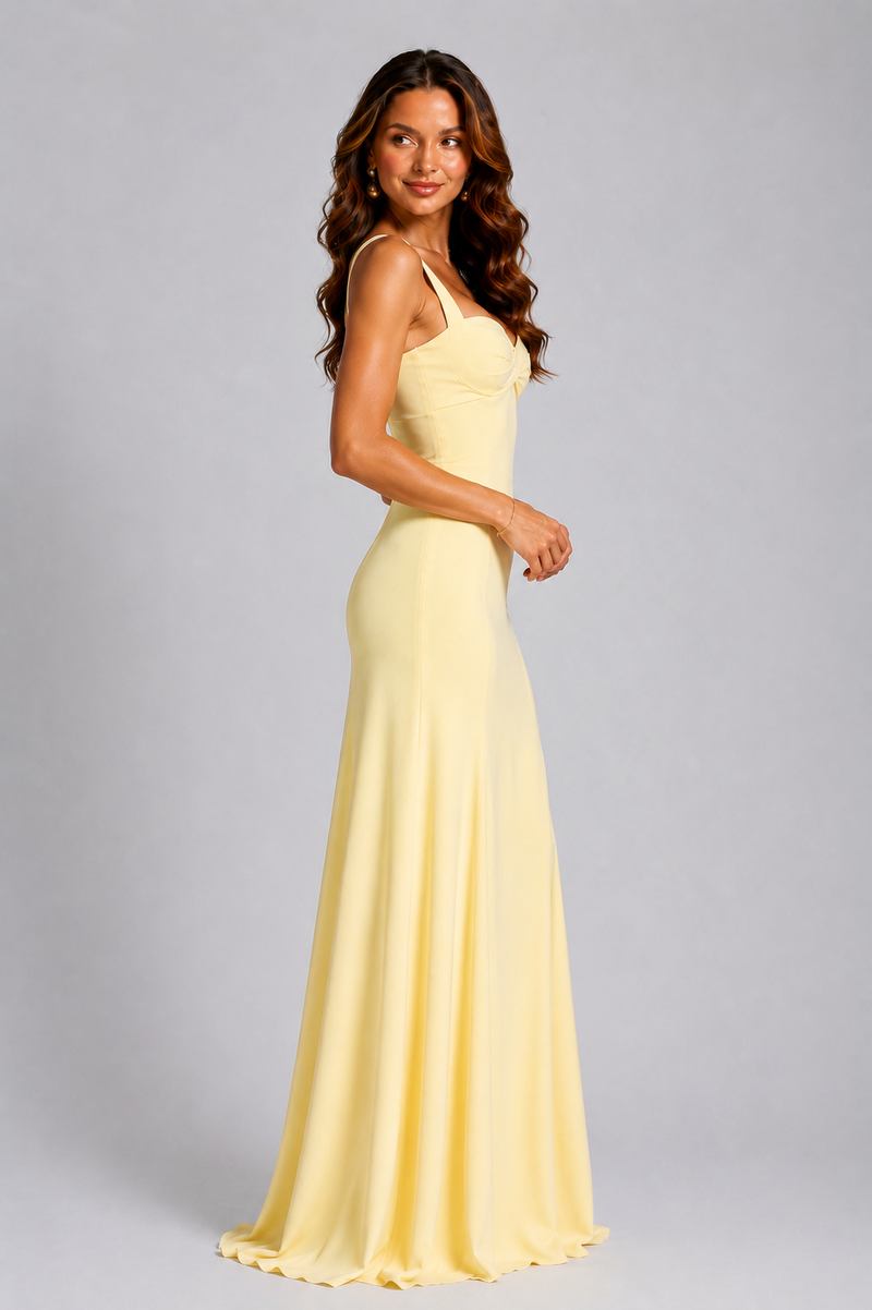 Woman wearing a yellow evening gown against a gray background